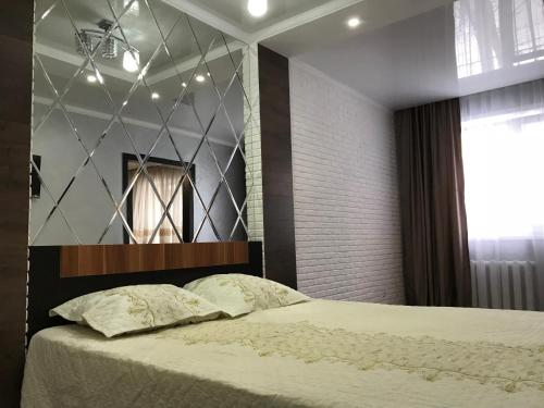 カラガンダにあるНовый Люкс в центре города по Алихановаのベッドルーム1室(壁に鏡付きのベッド1台付)