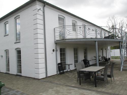 a white house with a table and a balcony at White House Hotel Apartments in Brande