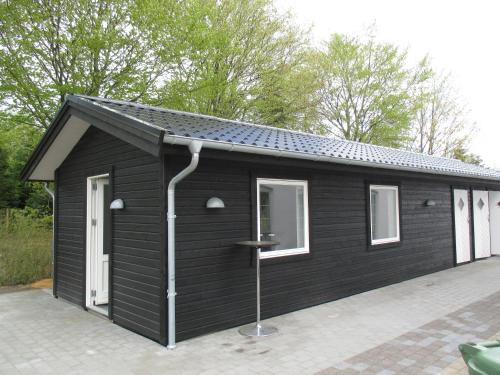 a black shed with a pitched roof at White House Hotel Apartments in Brande