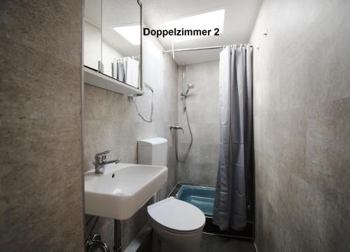 ein Badezimmer mit Waschbecken, Toilette und Dusche in der Unterkunft Bernsteinbäder Zimmer in Ostseebad Koserow