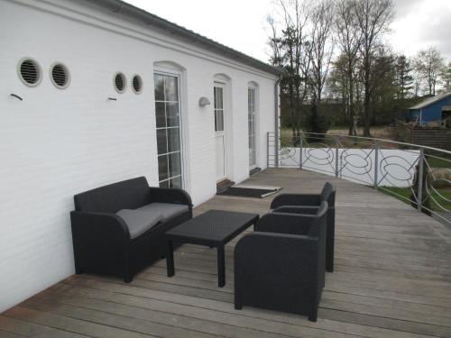 a deck with two chairs and a couch and a table at White House Hotel Apartments in Brande