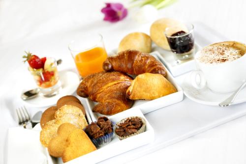 a tray of pastries and a cup of coffee and orange juice at Best Western Plus Royal Superga Hotel in Cuneo