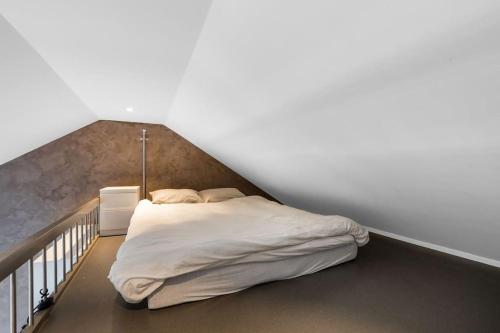 a bedroom with a bed in the corner of a room at 1-Roms toppleilighet på tangen/bystranda in Kristiansand