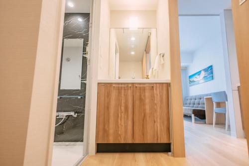 a bathroom with a shower and a wooden door at Far East Village Hotel Osaka, Namba South in Osaka