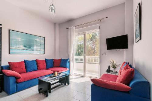 a living room with a blue couch and red pillows at Greek Style Apartment with Jaquzzi & Barbeque in Triánta