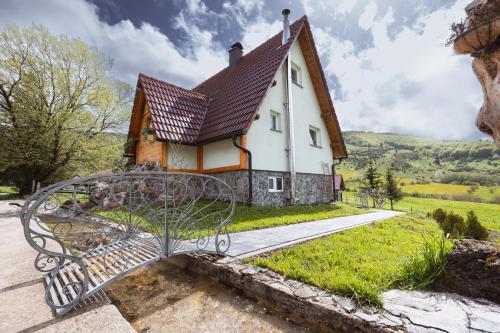 una panchina di fronte a una piccola casa di Mountain House Kosjenka a Kupres