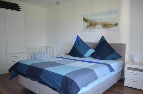 a bedroom with a blue and white bed with blue pillows at Yacht im Schiffehaus in Wangerland