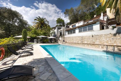 une piscine avec des chaises à côté d'un bâtiment dans l'établissement Belle maison atypique avec piscine chauffée, à La Colle-sur-Loup