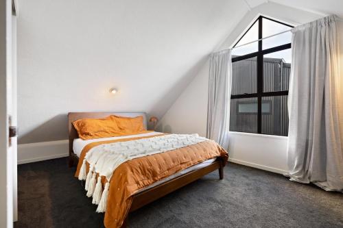 a bedroom with a bed and a large window at Remarkable Alpine Holiday Home in Queenstown