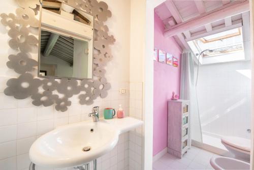 a bathroom with a sink and a mirror at Piombino Apartments - Casa Fucini in Piombino