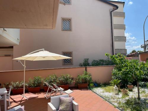 a patio with an umbrella and chairs and plants at The Loft E&E Open Space in Empoli