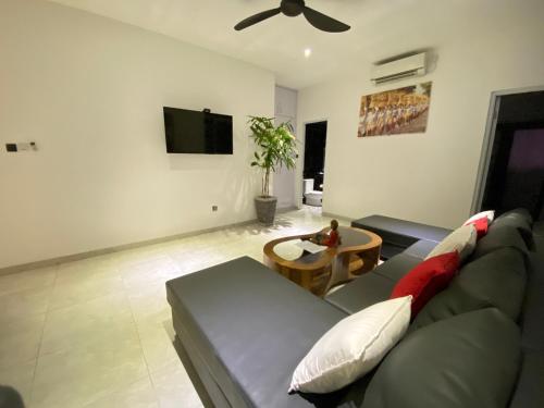 a living room with a couch and a tv at Villa Mabuk in Legian