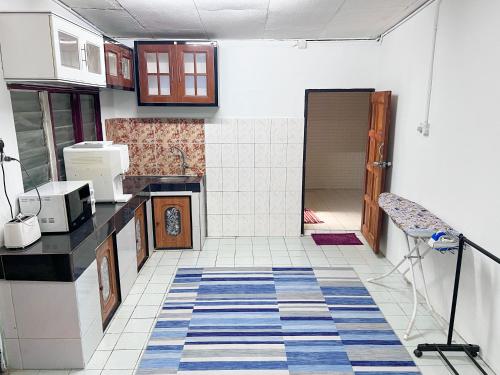 a kitchen with a counter top and a floor at Padang Besar Homestay Firdaus in Padang Besar