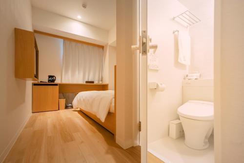 a small bathroom with a bed and a toilet at 谷町君Hotel 難波77 in Osaka