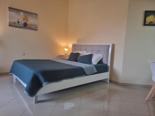 1 dormitorio con 1 cama grande con sábanas y almohadas azules en Nice Al Marjan studio en Ras al-Jaima