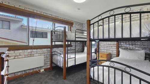 two bunk beds in a room with a window at Lawlers 29 in Mount Hotham