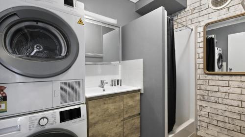 a bathroom with a washing machine and a sink at Lawlers 29 in Mount Hotham