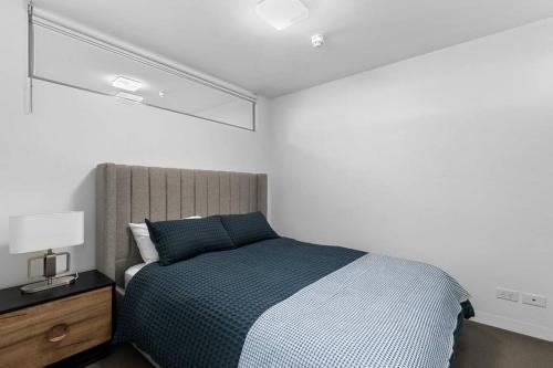 Perfect Urban Retreat! في ملبورن: غرفة نوم بسرير كبير مع بطانية زرقاء
