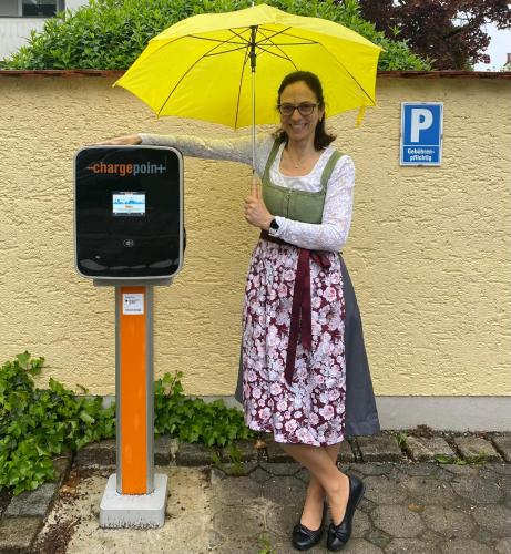 a woman holding an umbrella next to a pay phone at Simones Hotel Fürstenhof in Landshut