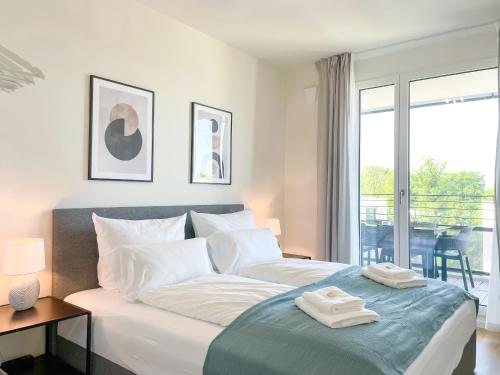 1 dormitorio con 1 cama con 2 toallas en E&K living - 6 pers - design apartment - fair - congress - parking, en Augsburg