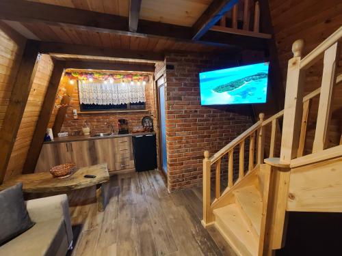 a living room with a staircase and a tv on a brick wall at Life on the farm in Nepravishtë
