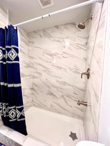 a bathroom with a bath tub with a blue shower curtain at Rustic Retreat Cottage in Payson