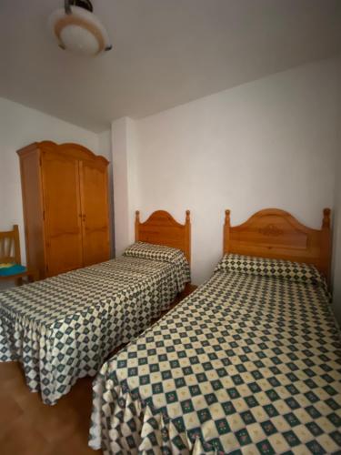 two beds sitting next to each other in a room at Chalet en la playa in Salobreña