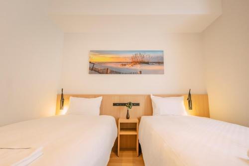 two beds sitting next to each other in a room at Far East Village Hotel Osaka, Namba South in Osaka