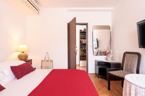 a bedroom with a bed and a desk and a television at Mirjana Apartment in Hvar