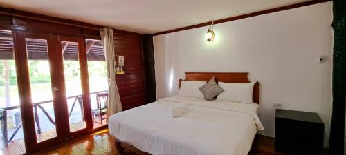 a bedroom with a bed with two glasses on it at Saithong Resort in Pak Meng