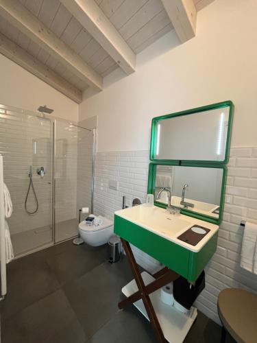 La salle de bains est pourvue d'un lavabo vert et d'une douche. dans l'établissement Glocal Torbole, à Nago-Torbole
