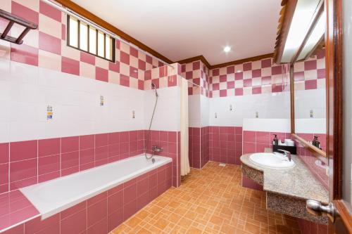 a pink and white bathroom with a tub and sink at Tony Resort in Patong Beach