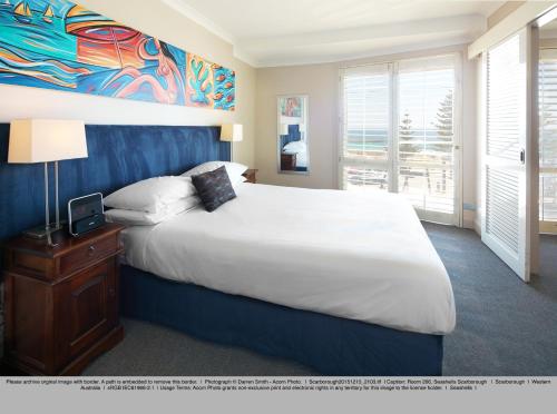 a bedroom with a large bed and a large window at Seashells Scarborough in Perth