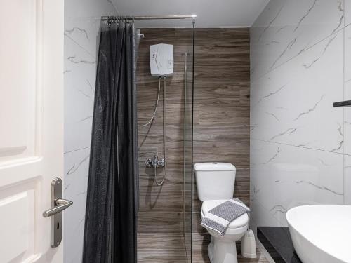 een badkamer met een douche, een toilet en een wastafel bij Sofia Apartments in Kalamaki