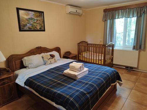 ein Schlafzimmer mit einem Kinderbett mit zwei Handtüchern auf einem Bett in der Unterkunft Country House Uliana in Zqaltubo