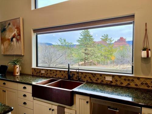 a kitchen with a sink and a large window at Sedona Uptown Gem! Wow! Views!! Close to trails, walk to Uptown Sedona, restaurants and shopping in Sedona