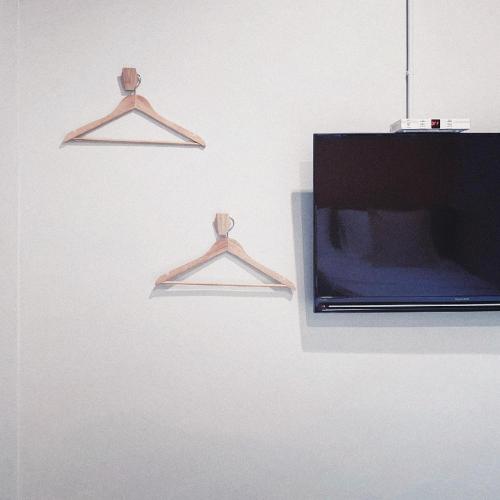 a television hanging on a wall with two hangers at Into the town krabi in Krabi town