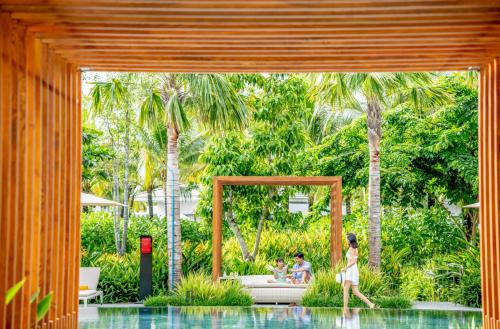 a woman walking through a pool in a house at Crowne Plaza Phu Quoc Starbay, an IHG Hotel in Phu Quoc