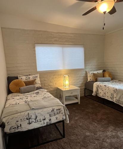 a bedroom with two beds and a window at Sedona Uptown Gem!Large yard w grass and shade trees! Views!! NEW! BARREL SAUNA!!! Close to trails, walk to Uptown Sedona, restaurants and shopping in Sedona