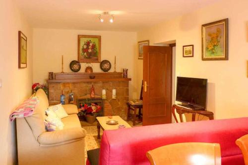 a living room with a red couch and a fireplace at Casa Rural La Pereda in Noriega