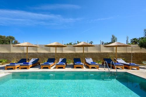 una piscina con sedie a sdraio e ombrelloni di Villa Anolia with Private Pool a Koskinou