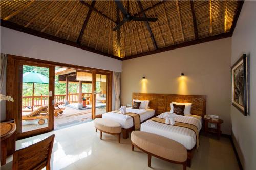 sypialnia z 3 łóżkami i patio w obiekcie The Lokha Ubud Resort, Villas & SPA w mieście Ubud