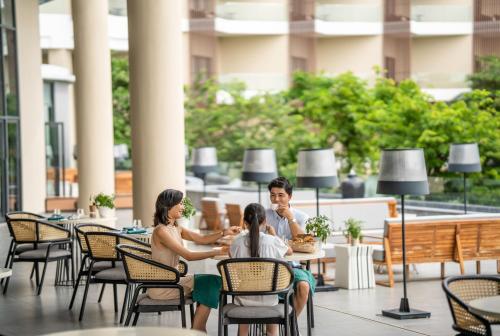 a group of people sitting at a table in a restaurant at Crowne Plaza Phu Quoc Starbay by IHG in Phu Quoc