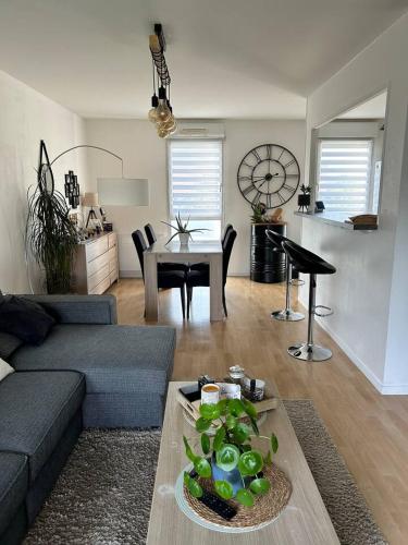 un salon avec un canapé et une table dans l'établissement Appartement une chambre proche centre ville et transports, au Mans