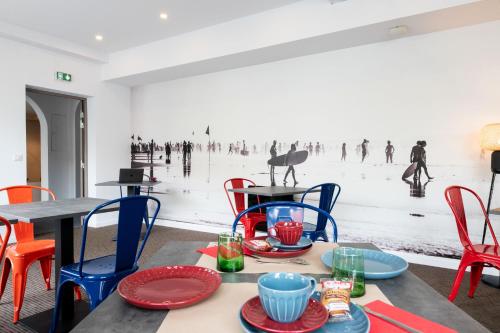une salle à manger avec des tables et des chaises et un tableau de personnes dans l'établissement Urban Style Biarritz Le Relais, à Biarritz