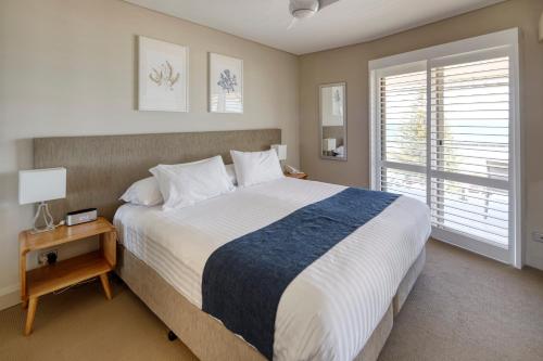 Un dormitorio con una cama grande y una ventana en Seashells Scarborough, en Perth