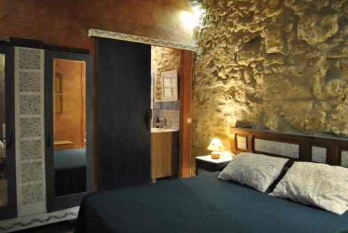 una camera con letto e parete in pietra di Casa Rural Los Secretos a Carbonero de Ahusín
