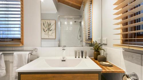 a bathroom with a white sink and a shower at Altitude in Dinner Plain