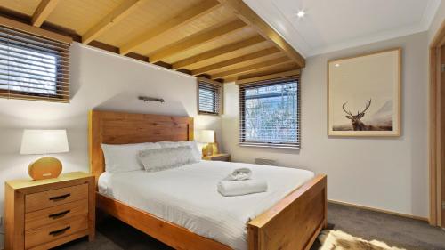 a bedroom with a large bed and two windows at Altitude in Dinner Plain