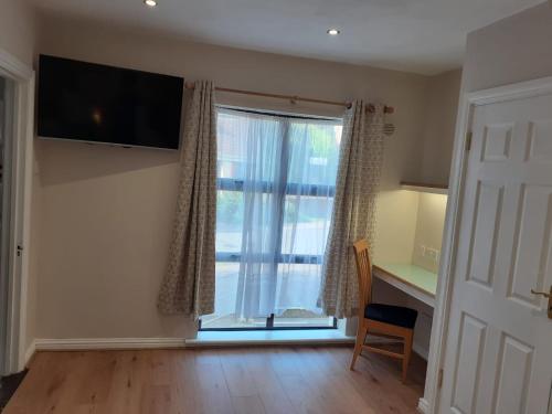 a living room with a large window and a desk at THE FORTWELL BOARDING HOUSE in Letterkenny